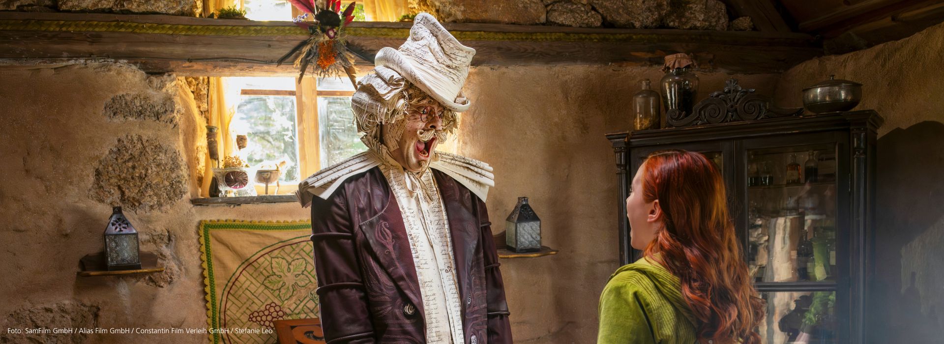 Szene aus dem Film ‘Ein Mädchen namens Willow’: Willow und Grimmoor stehen in einer Hütte und blicken sich erschrocken an. Grimmoor besteht aus Buchseiten und hat einen lustigen Schnauzbart.